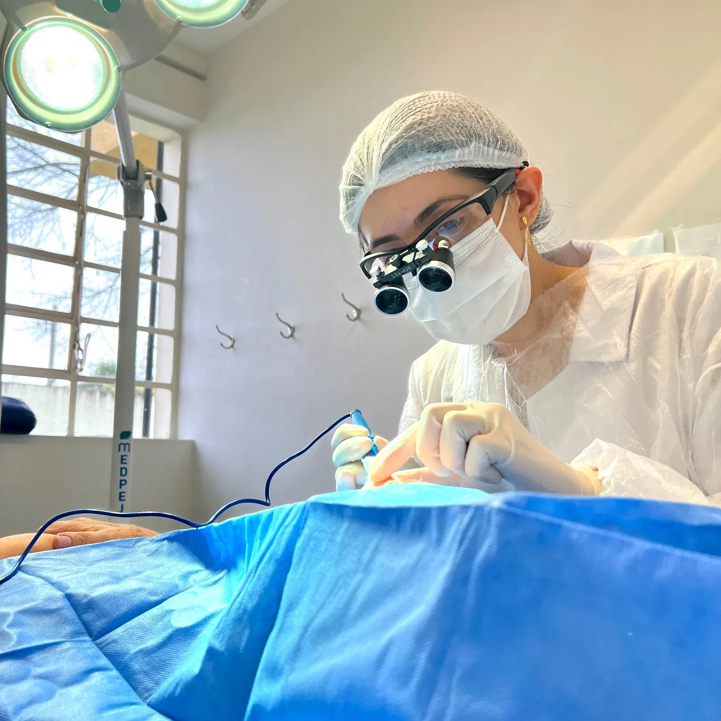 Dra. Priscila Francisco realizando uma cirurgia dermatológica com lupa cirúrgica